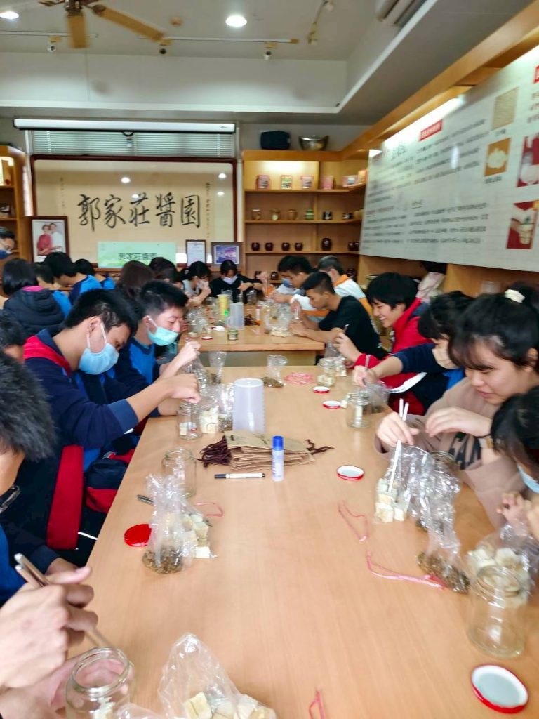 職場參訪郭家莊-學生學習將豆腐塊整齊放入玻璃瓶內.jpg